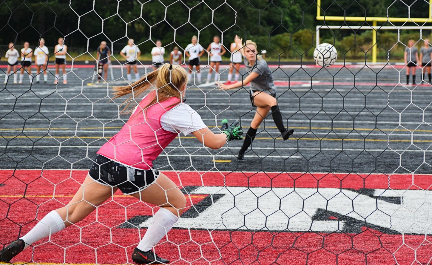 Tenino's Morgan Miner knocks in a shot against W.F. West's Carlie Deskins during a penalty-kick shootout with the Bearcats on Saturday.